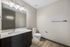 Elegant bathroom with a modern vanity, large mirror, and sleek fixtures, showcasing a minimalist design.