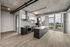 Modern open-concept kitchen with sleek cabinetry, stainless steel appliances, and panoramic city views through large windows.