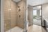 Modern bathroom with sleek glass shower and stunning city view from the doorway.