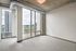 Modern apartment interior with large floor-to-ceiling windows offering stunning cityscape views, featuring sleek industrial ductwork and elegant carpeting.