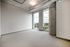 Modern urban apartment space with large windows offering stunning city views, high ceilings, and sleek exposed piping.