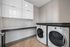 Modern laundry room featuring high-efficiency washer and dryer, sleek cabinets, and ample folding space.