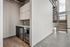 Modern apartment featuring sleek kitchen cabinetry, stainless steel appliances, and elegant staircase leading to upper level with panoramic views.