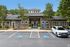 Charming residential community entrance with modern architecture, lush landscaping, and convenient parking in a serene setting.