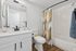 Contemporary bathroom featuring elegant white cabinetry, sleek fixtures, and a stylish shower curtain for a modern touch.