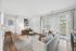 Bright and inviting living room with large windows, stylish decor, and warm wood flooring, offering a cozy and modern atmosphere.