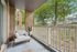 Charming apartment balcony with cozy seating, surrounded by lush trees and serene views.