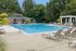 Inviting outdoor pool oasis with stylish lounge chairs and lush greenery, perfect for relaxation and leisure.