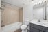 Modern bathroom with stylish fixtures, a sleek vanity, and elegant tiled bathtub.