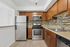 Modern kitchen with stainless steel appliances, granite countertops, and warm wooden cabinetry for a sleek design.