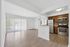 Inviting open-plan living space featuring modern kitchen with stainless steel appliances, elegant cabinetry, and natural light streaming through large sliding glass doors.