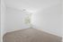Bright and spacious bedroom with plush carpet and a large window, perfect for natural light.