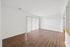 Bright and spacious living area with elegant wood flooring and large window blinds, ideal for hosting and relaxation.
