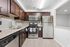 Modern kitchen with stainless steel appliances, granite countertops, and elegant dark wood cabinetry.