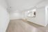 Bright and spacious living area with sleek hardwood floors, modern recessed lighting, and an inviting open-concept kitchen.