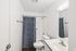 Modern bathroom with sleek fixtures, white vanity, and a stylish blue shower curtain, offering a refreshing and clean design.