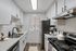 Chic modern kitchen with sleek white cabinets, stainless steel appliances, and elegant marble countertops.