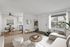 Elegant living space with a cozy dining area, contemporary kitchen, and stylish decor. Large windows fill the room with natural light, highlighting the modern interior design.