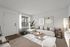 Bright and inviting living room with modern decor, featuring a cozy sectional sofa, elegant artwork, and natural light from large windows.