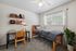 Cozy bedroom featuring a stylish workspace, modern decor, and inviting natural light.