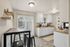 Charming kitchen with modern white cabinetry, sleek countertops, and natural light through sliding glass doors.