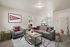 Inviting living room with modern gray furniture, vibrant red accents, and a chic wall mirror, perfect for relaxation and style.