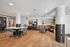 Modern communal space with sleek countertops, stylish seating, and vibrant artwork, ideal for social gatherings or relaxed coworking.
