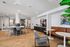 Modern communal lounge featuring stylish seating, vibrant artwork, and sleek countertops with a coffee station, creating an inviting atmosphere.