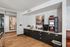 Chic coffee station with modern art and sleek cabinetry in a stylish apartment setting.