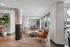 Bright, sophisticated lounge space featuring stylish wicker chairs, modern decor, and large windows overlooking a pool area.