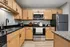 Modern kitchen with sleek stainless steel appliances, elegant granite countertops, and stylish wooden cabinetry.