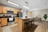 Contemporary kitchen and dining area with sleek appliances, granite countertops, and warm wood finishes, ideal for modern living.
