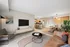 Inviting contemporary living space with modern decor, open kitchen, and cozy seating area, bathed in natural light.