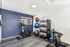 Modern fitness room featuring state-of-the-art exercise equipment, including stationary bikes and variety of weights, in a bright, well-lit space with contemporary decor.