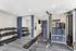 Modern fitness room equipped with dumbbells and versatile exercise machines in a stylish, bright setting.