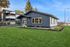 Inviting leasing office with modern architecture set against a lush, green lawn under a clear blue sky.