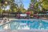 Inviting outdoor scene with a sparkling pool, vibrant playground, and lush green surroundings.