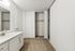 Elegant bathroom featuring modern white cabinetry, sleek sink, and ample closet space perfect for organized living.
