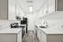 Modern kitchen with sleek white cabinetry, elegant marble countertops, and contemporary stainless steel appliances.