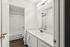 Bright and modern bathroom with sleek vanity, large mirror, and elegant fixtures, perfect for a relaxing retreat.