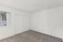 Bright and airy bedroom with plush, patterned carpet and large window, offering an inviting blank canvas for your dream space.