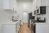 Modern kitchen with sleek white cabinetry, stainless steel appliances, and elegant black fixtures, offering a contemporary and functional space.