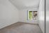 Bright bedroom with plush carpet, large window offering scenic views and ample natural light.