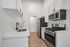 Modern kitchen with sleek stainless steel appliances, crisp white cabinetry, and elegant marble countertops.