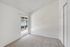 Bright and airy bedroom with plush carpeting and sliding glass door for ample natural light.
