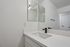 Sleek modern bathroom with a marble countertop, elegant black fixtures, and a minimalistic design.