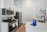 Modern kitchen with sleek white cabinetry, stainless steel appliances, and elegant marble countertops, offering a stylish and functional cooking space.