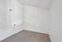 Bright and airy room with plush carpet and modern white walls, perfect for a cozy bedroom or office space.