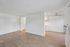 Bright and modern living space with sleek wood floors, neutral walls, and a contemporary ceiling fan, perfect for open-concept living.
