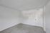 Bright and versatile empty room with fresh carpet, minimalist white walls, and modern door, ready for personalization.